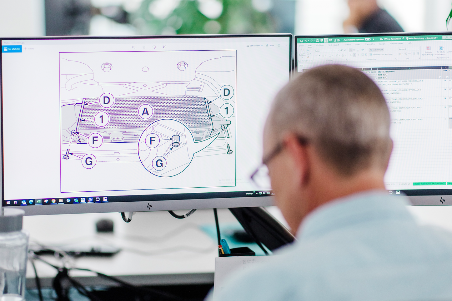 Ingenieur bei der technischen Analyse am Bildschirm Ein Ingenieur sitzt an seinem Schreibtisch und schaut konzentriert auf zwei Bildschirme. Auf dem linken Bildschirm ist eine technische Zeichnung mit beschrifteten Bauteilen zu sehen, auf dem rechten Bildschirm ein Excel-Dokument. Auf dem Tisch liegen Kopfhörer, ein Smartphone und Dokumente.